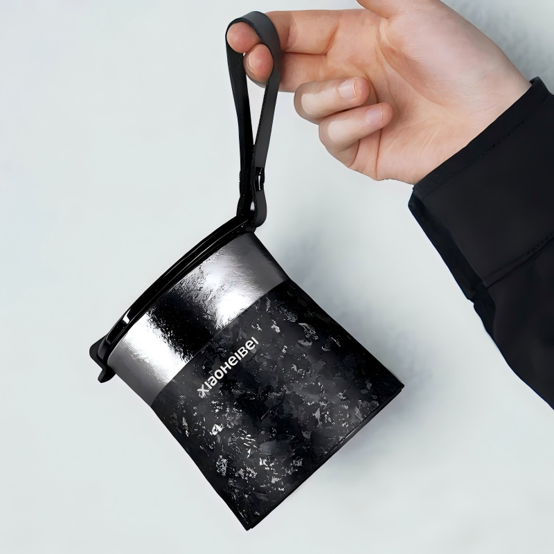 Кофейная кружка BlackInTi из чистого титана — рука держит кружку за чёрный ремешок для переноски
