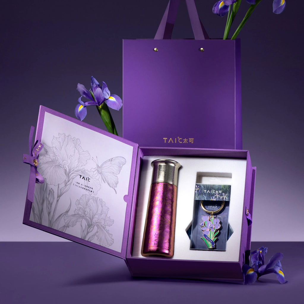 Pure titanium tumbler in iridescent iris purple standing in open TAIC gift box with iris flower charm and card
