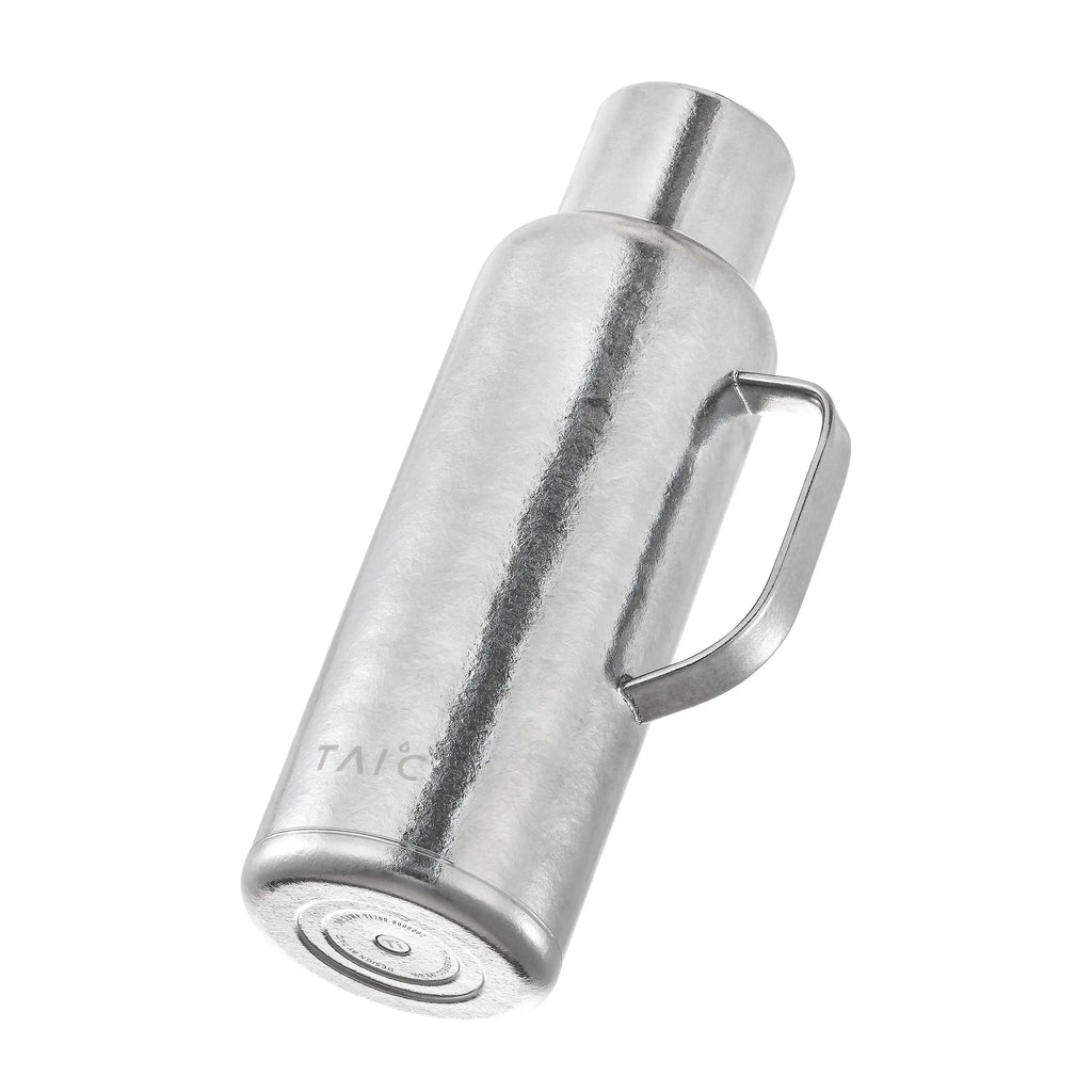 Pure titanium 1.2L thermal carafe tilted to reveal engraved titanium base and model marking, silver finish