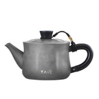Matte grey pure titanium teapot, side profile showing blackwood loop handle and hammered body