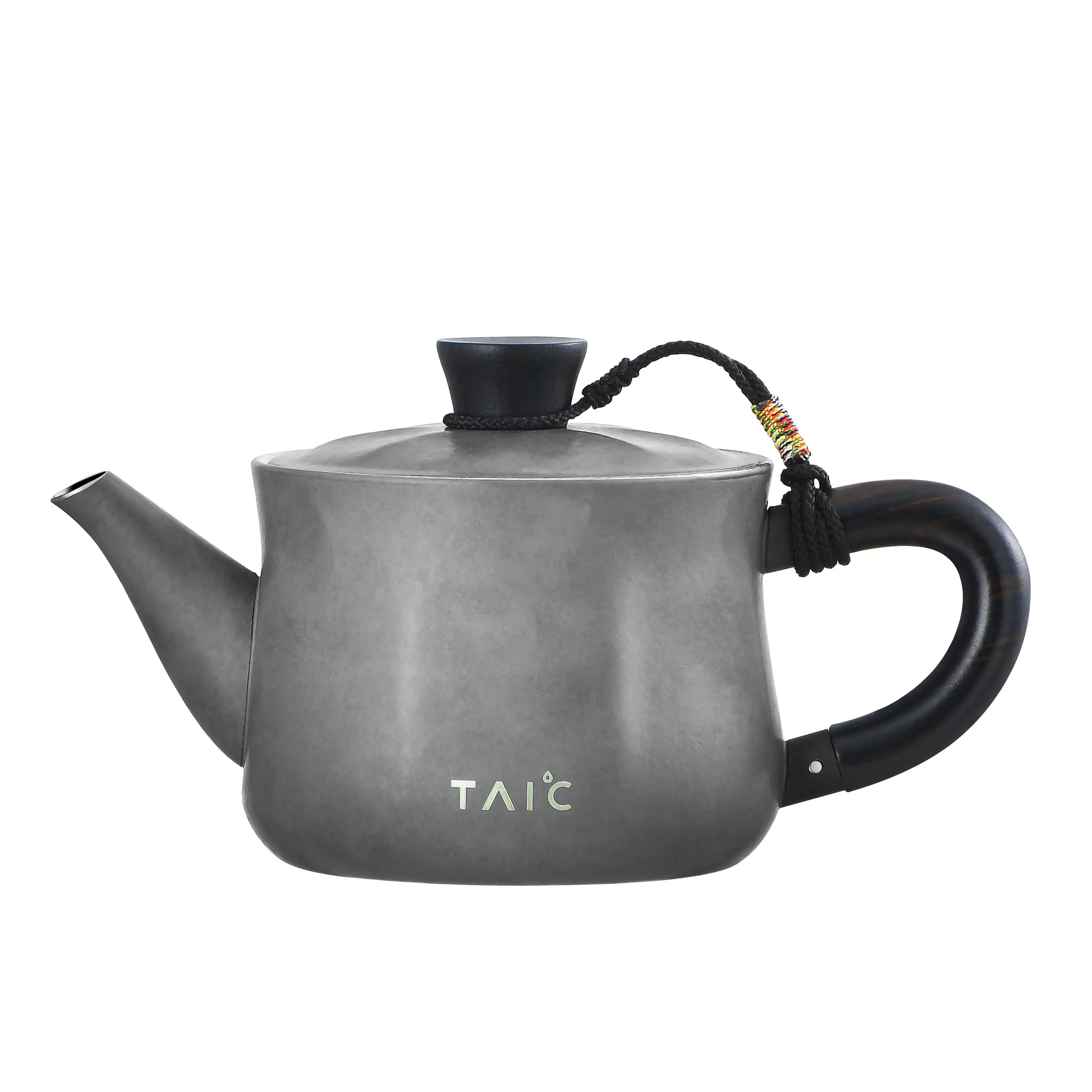 Matte grey pure titanium teapot, side profile showing blackwood loop handle and hammered body