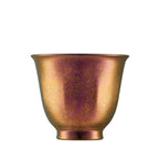 Single rose-copper iridescent pure titanium tea cup with gold flecks, front view on white background