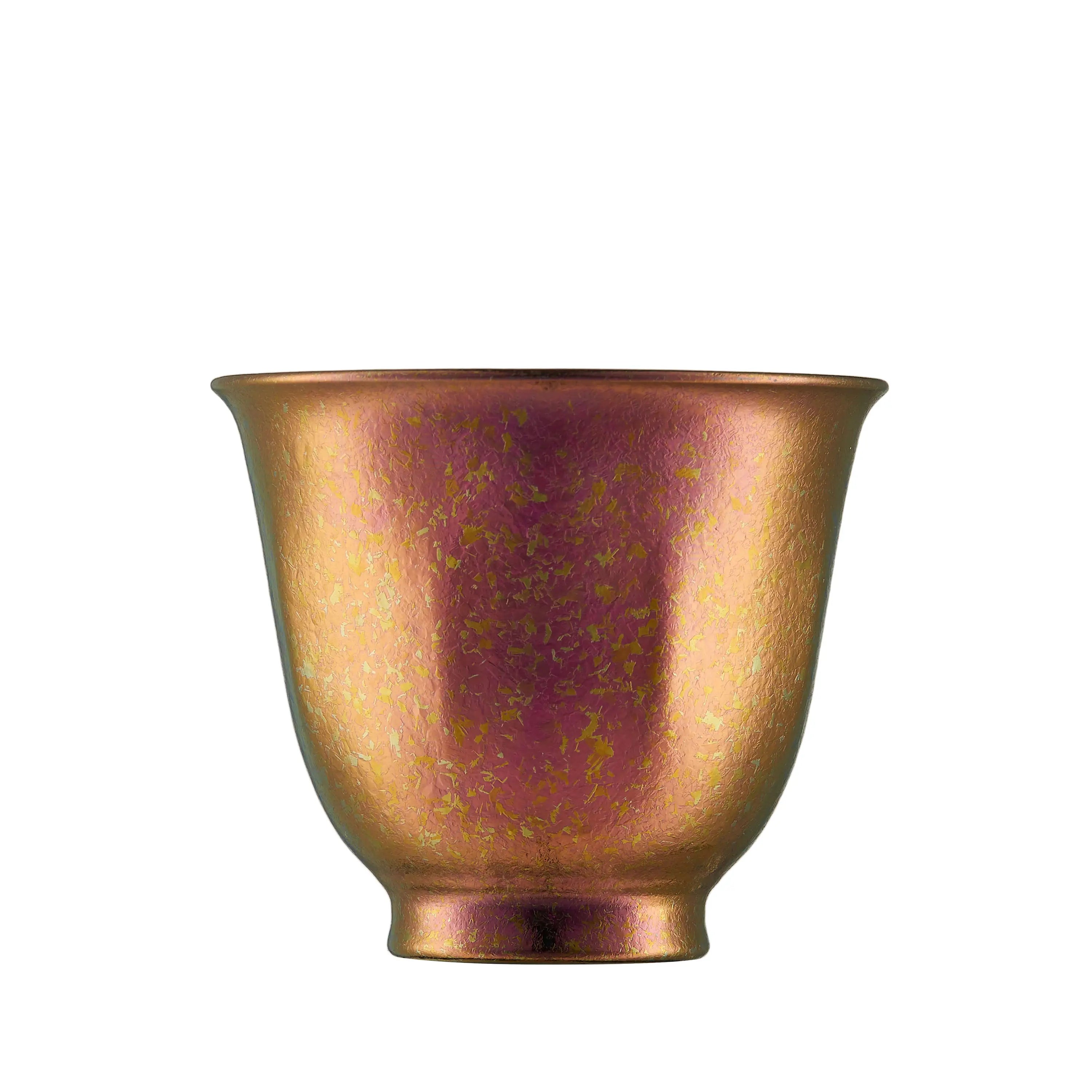 Single rose-copper iridescent pure titanium tea cup with gold flecks, front view on white background