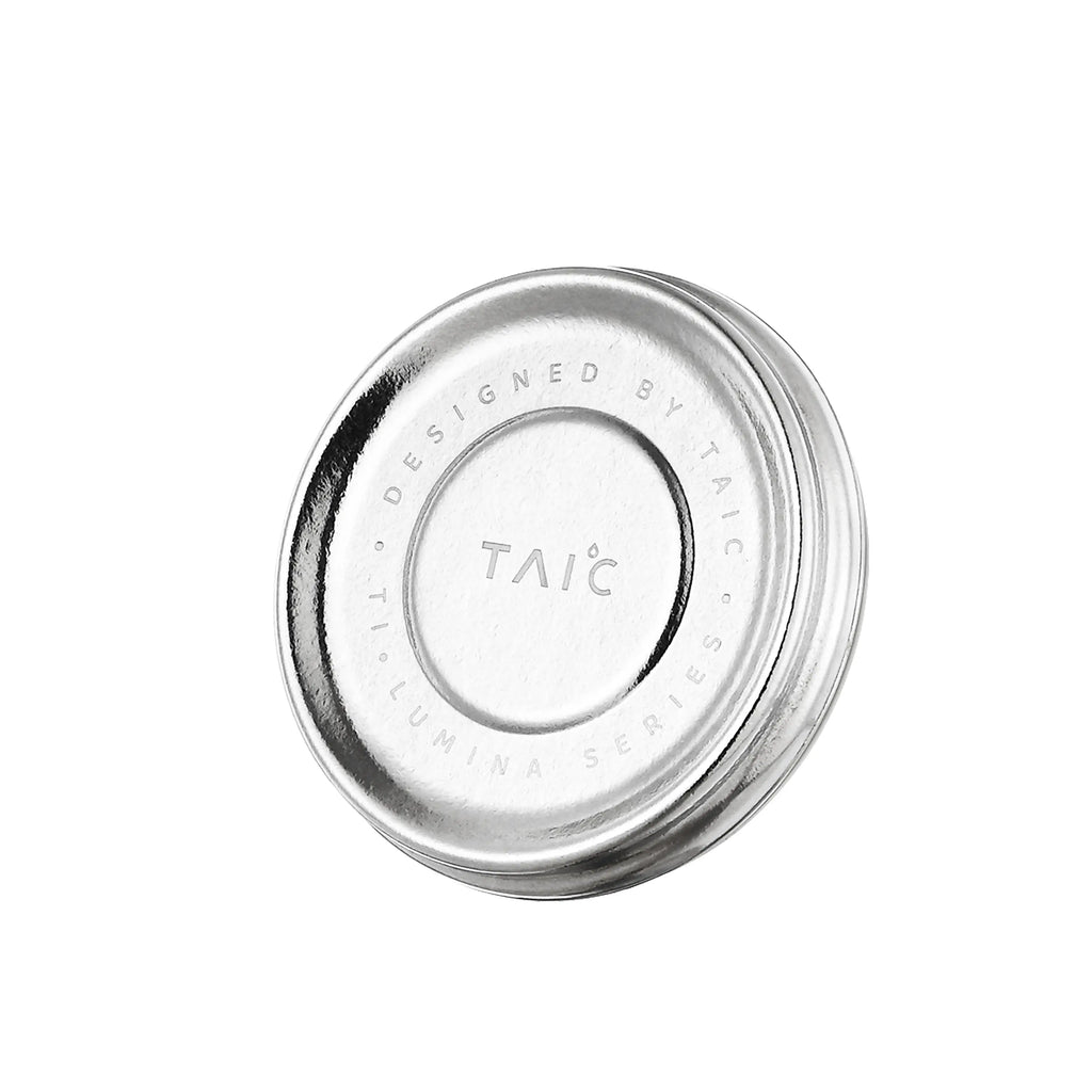 Close-up of titanium mug lid engraved 'Designed by TAIC Ti Lumina Series', top view