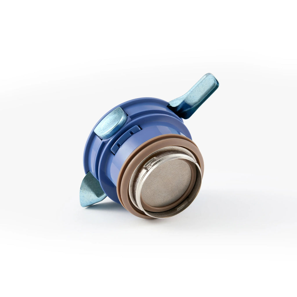 Detail of the blue press-to-lock lid module and sealing gasket from the titanium thermal carafe
