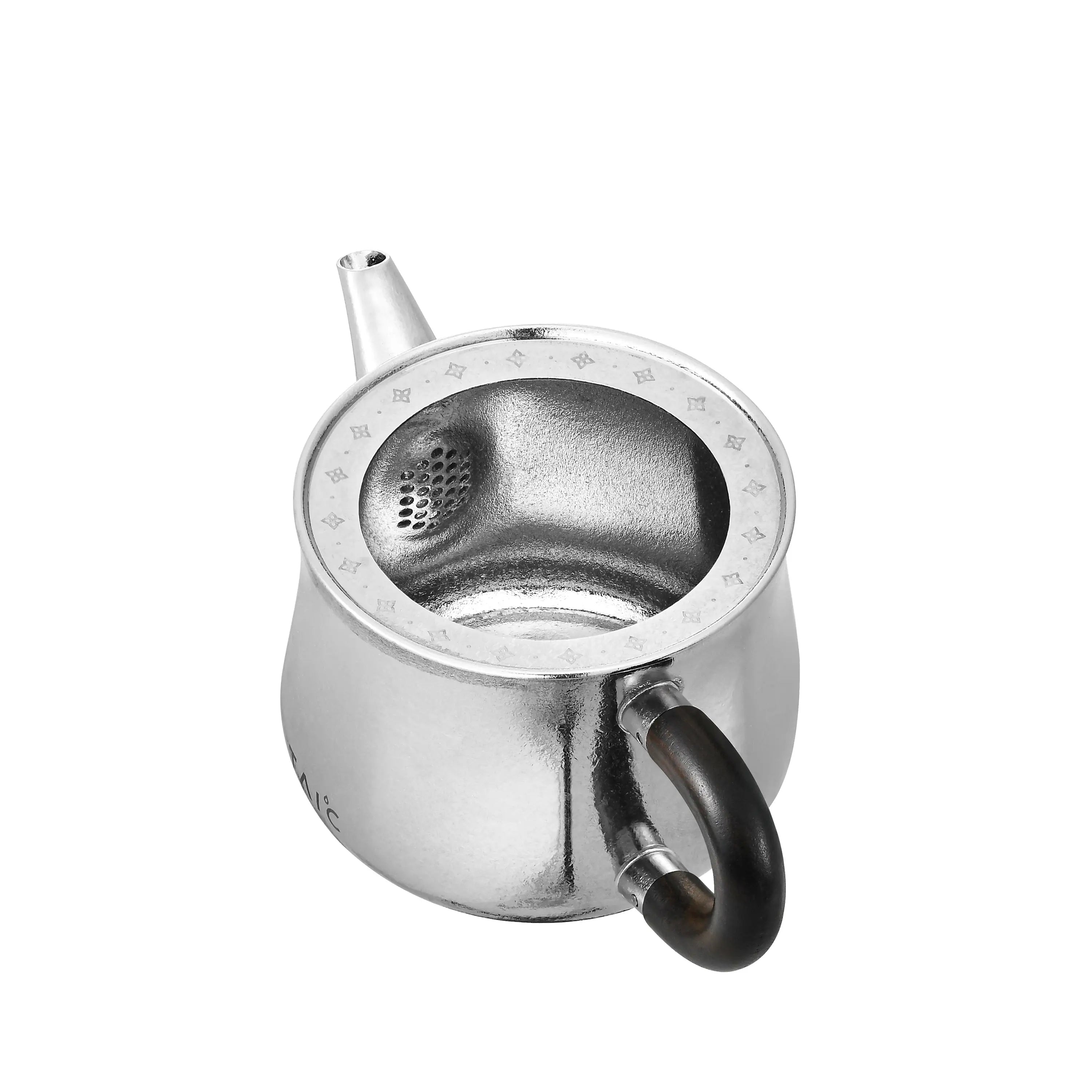 Titanium teapot with lid off, top-down view of interior and built-in honeycomb strainer at spout