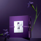 Closed purple titanium tumbler gift box with silver iris-and-butterfly cutout card and ribbon bow, single iris stem