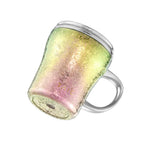 Iridescent titanium mug tilted to reveal its rounded base, 45-degree angle view