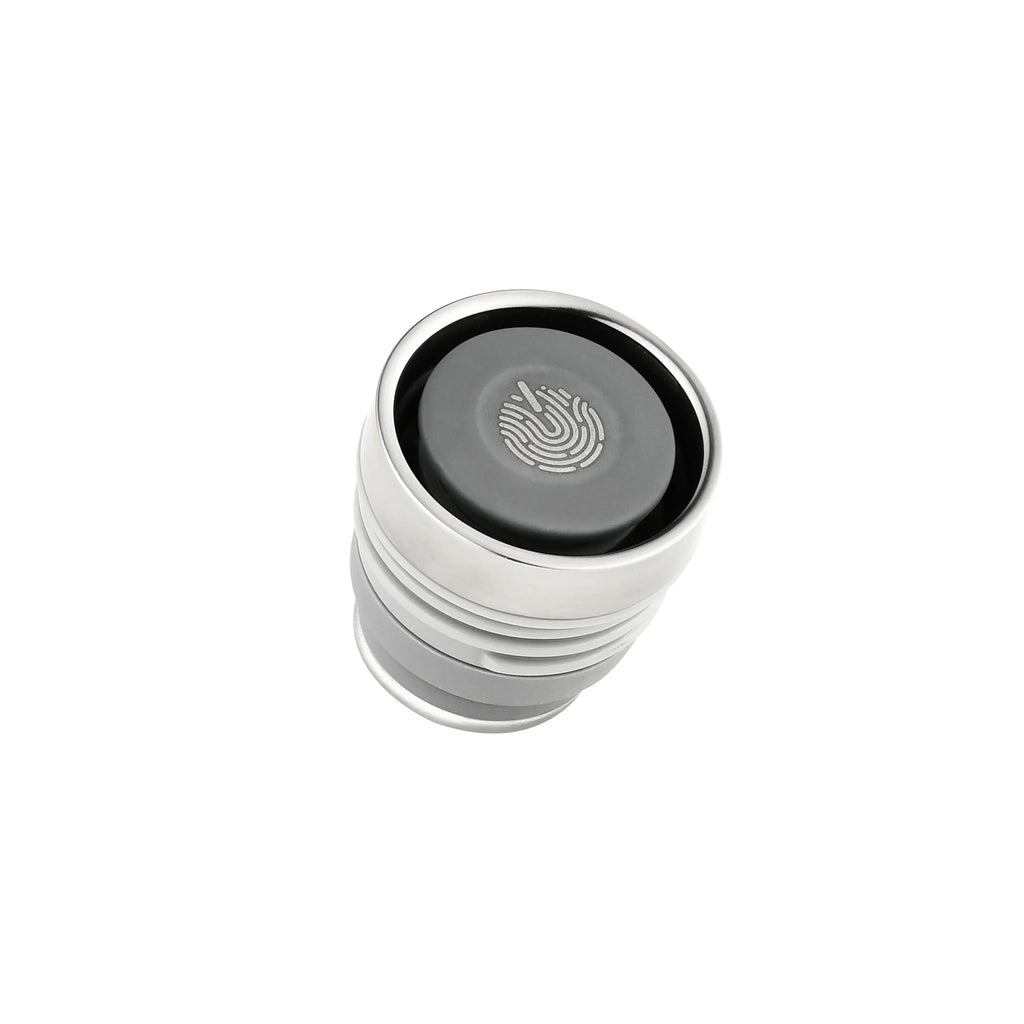 Monet Sailboat titanium infuser tumbler lid, top-down close-up of press button with etched wave emblem