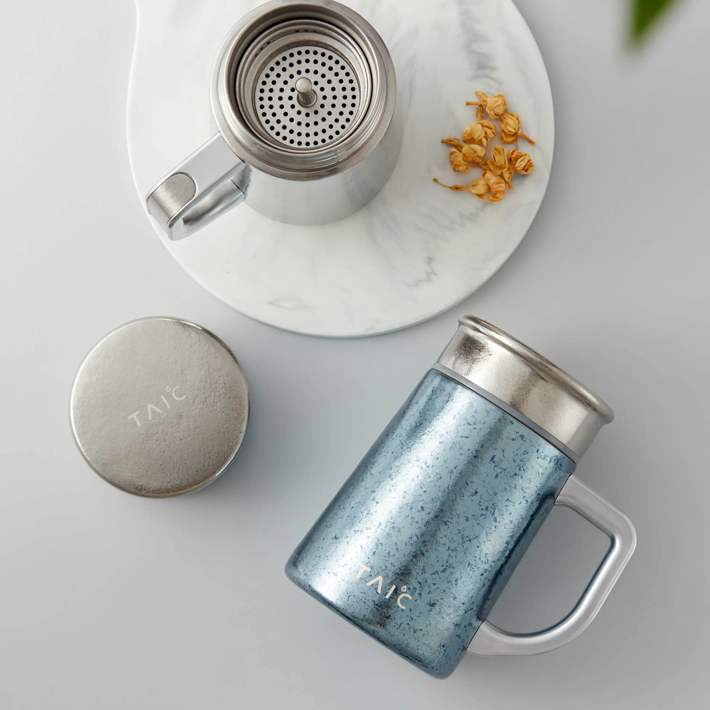 Pure titanium office mug 450mL top view with micro-mesh infuser and round lid beside jasmine flowers