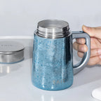 Pure titanium aurora-gradient office mug 450mL with lid lifted off showing open rim, held in hand