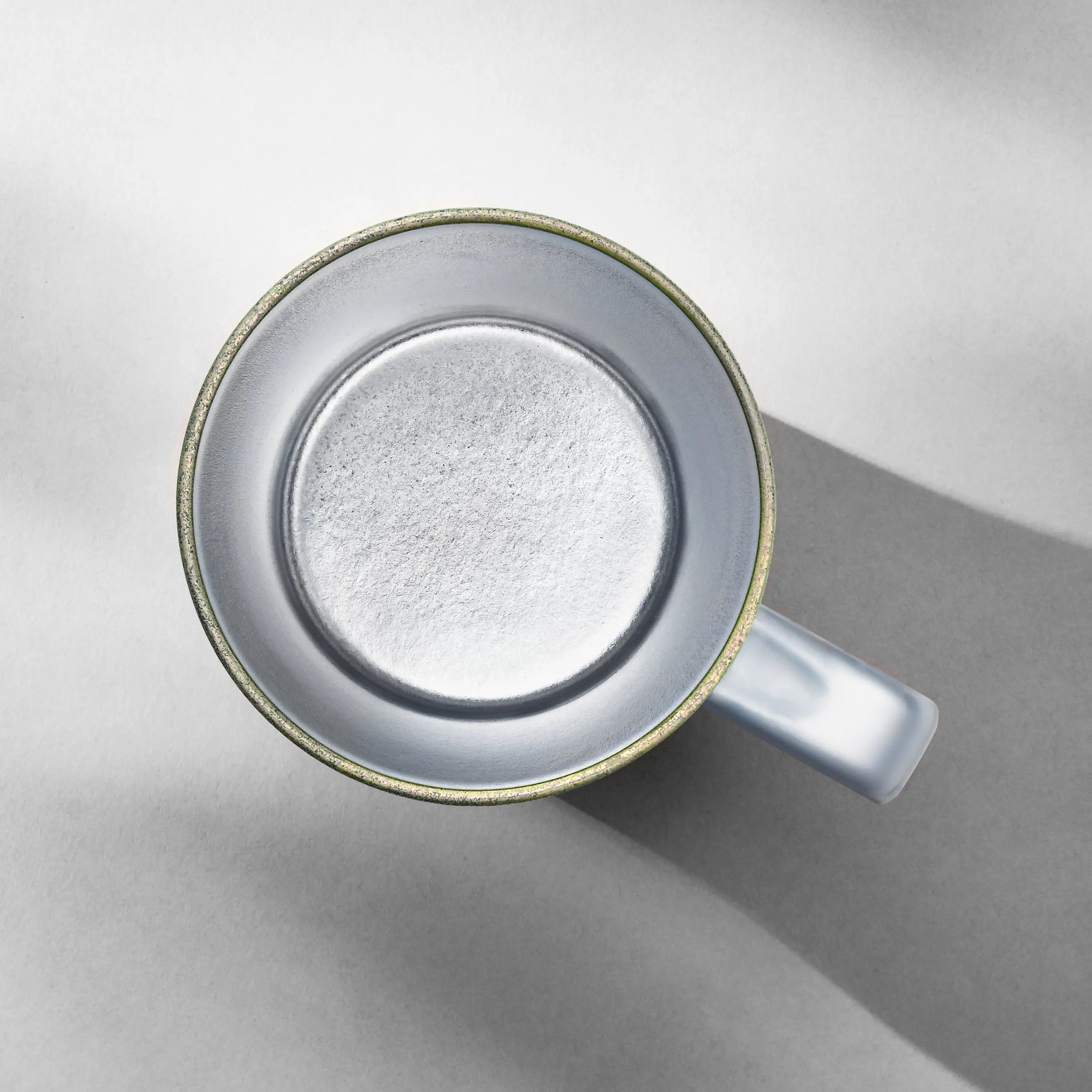 Top-down view into an empty titanium mug showing its seamless wide-mouth interior liner