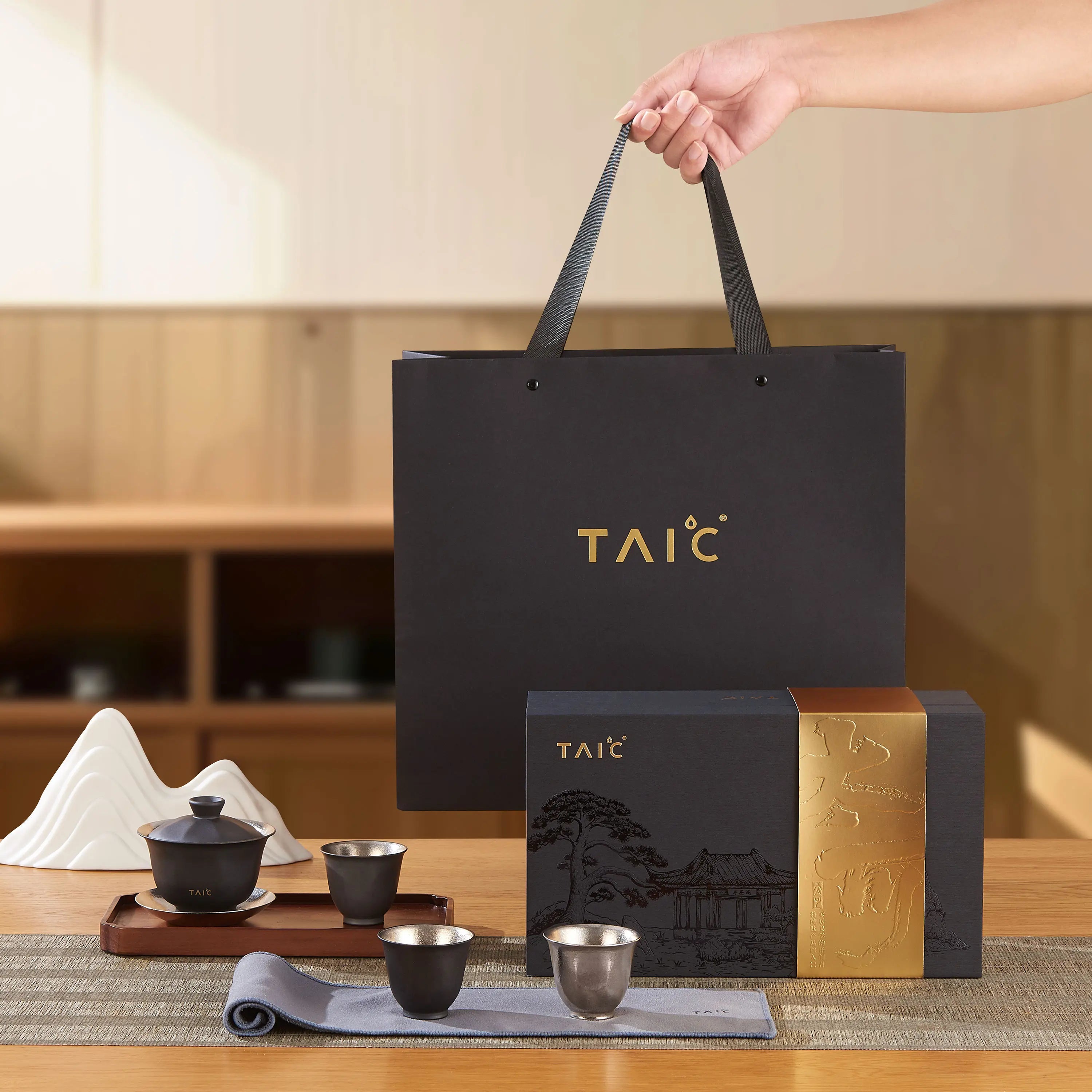 Pure titanium travel tea set styled on wood table with gaiwan, cups, gift box and shopping bag