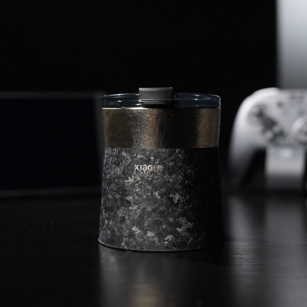 Кофейная кружка BlackInTi из чистого титана — крупный план на тёмном столе с закрытой крышкой, контроллер сзади